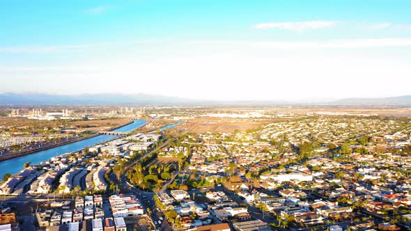 Panning drone shot of the San Gabriel River over to the Seal Beach Pier. alt