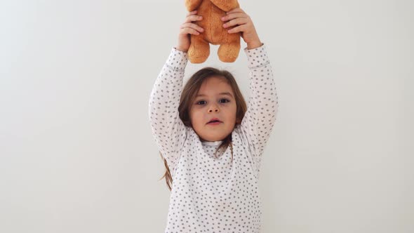 Funny Preschool Girl Making with Teddy Bear Toy Candid Lifestyle Child Portrait with Emotions alt