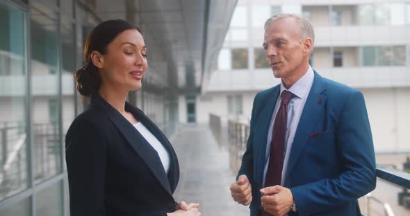 Business Colleagues Smiling and Talking Outside Office Building alt