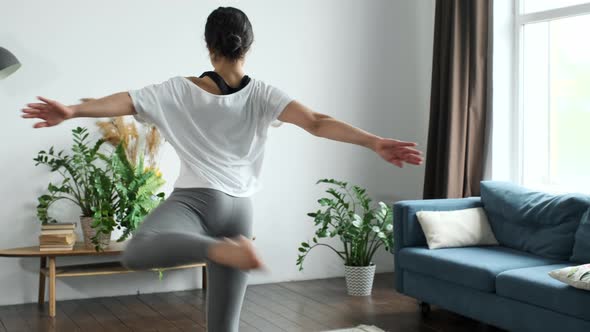 A young Indian Woman trains at home, Does a Spinning exercise, Bright Cozy Room alt