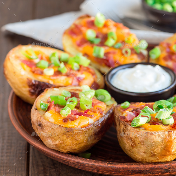 Baked loaded potato skins with cheddar cheese and bacon, garnish Stock ...