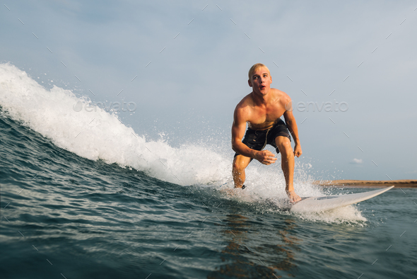 guy swims on a surf on a blue wave