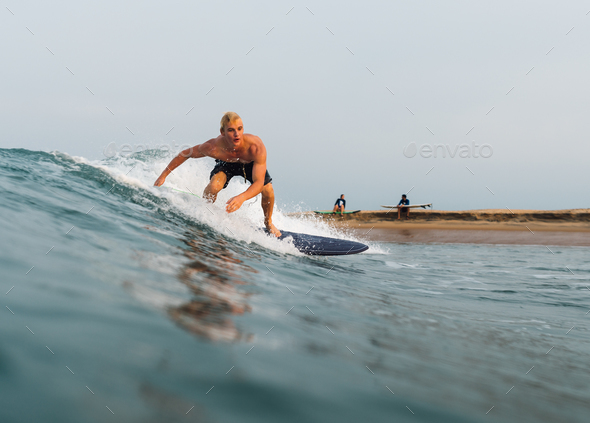 guy swims on a surf on a blue wave