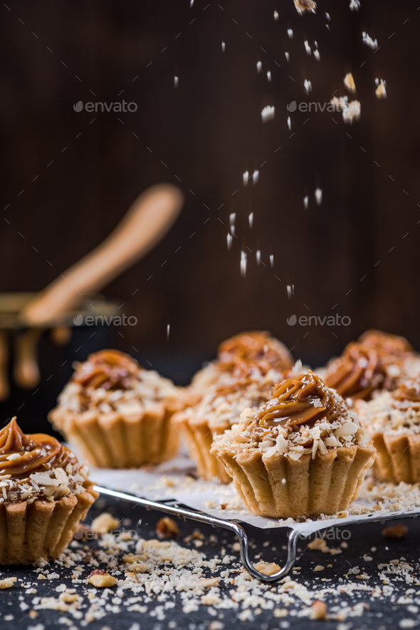 Topping salted caramel cupcakes with walnuts