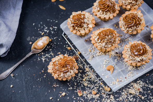 Topping salted caramel cupcakes with walnuts