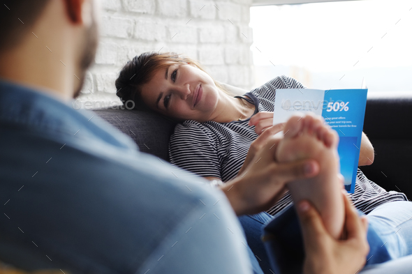Man Massaging Girlfriend Feet On Sofa At Home - Stock Photo - Images