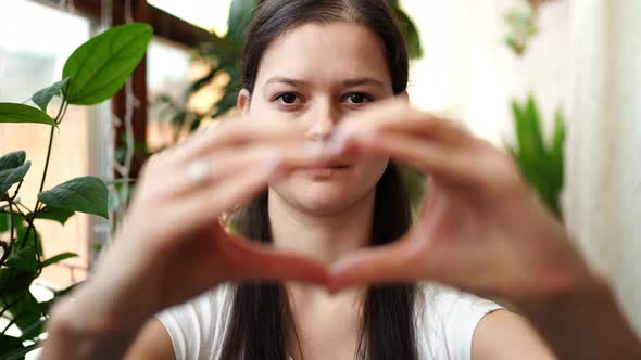 Young RussianUkrainian Girl with the Flag of Ukraine and Russia on Her Face is Showing Heart By alt