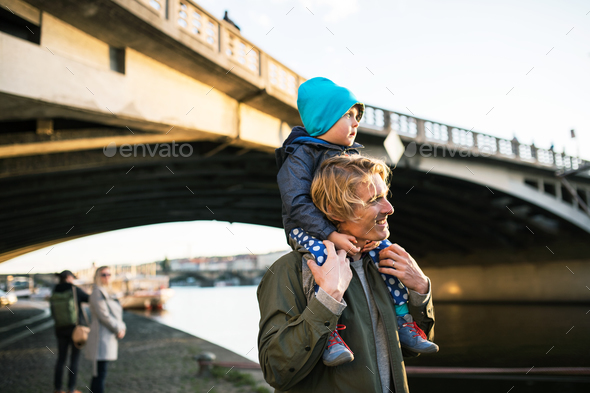 Happy mother giving her son a piggyback ride in the city stock photo