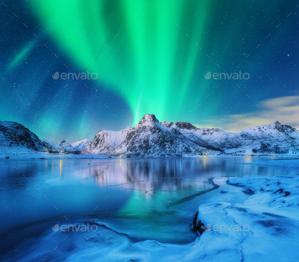 Aurora borealis over snowy mountains, frozen sea coast - Stock Photo - Images