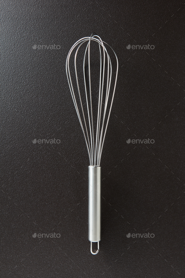 Kitchen metal beater on a black concrete background with copy space. Kitchen appliance for cooking - Stock Photo - Images