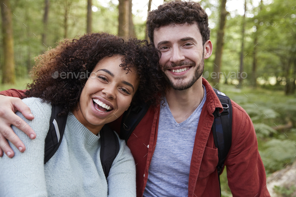 A Young Adult Mixed Race Couple Laughing To Camera During A Hike In A Forest Portrait Stock