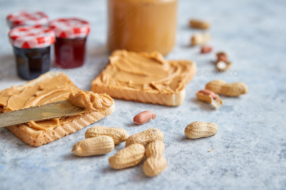 Two tasty peanut butter toasts placed on stone table - Stock Photo - Images