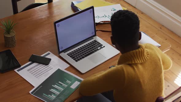 Overhead view of african american woman having a videocall on laptop while working from home alt