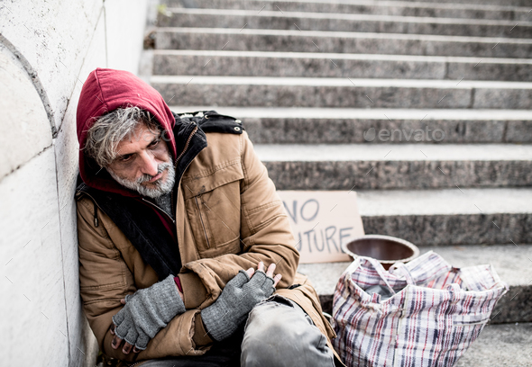 Homeless beggar man sitting outdoors in city asking for money donation ...