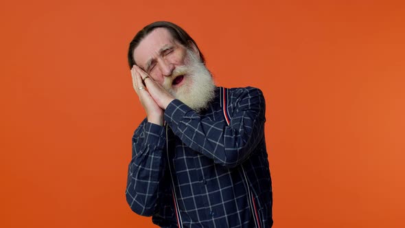 Tired Elderly Bearded Man Going to Sleep Laying Down on His Palms Yawning Dozing Off During Day alt