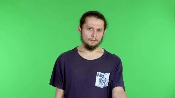 Portrait of a Young Man Looking at the Camera and Talking Indignantly with Someone alt