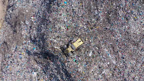 Flying Above a Bulldozer Working on a Landfill Full With Garbage alt