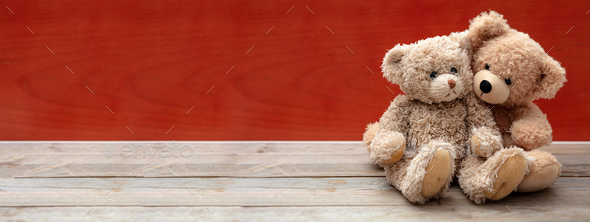 Love, friendship concept, tight hug. Teddy bears couple on wooden floor,  red wall background Stock Photo by rawf8
