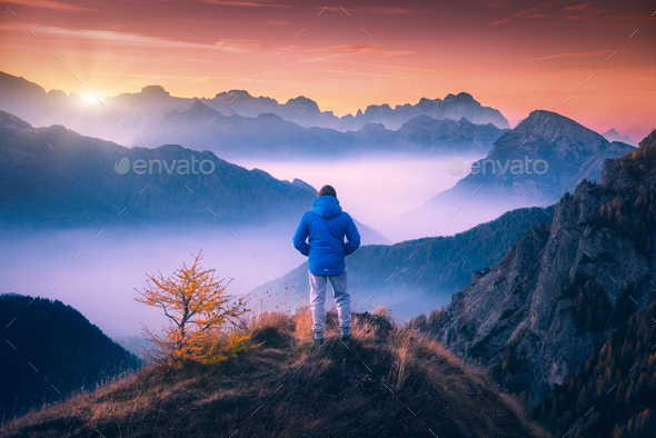 Man on the mountain peak looking on mountain valley - Stock Photo - Images