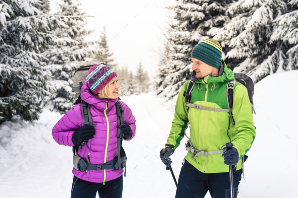 Couple hikers trekking in winter woods - Stock Photo - Images