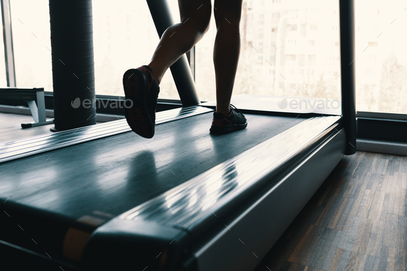 Early morning sport, female legs running on the gym treadmill ea Stock  Photo by arthurhidden