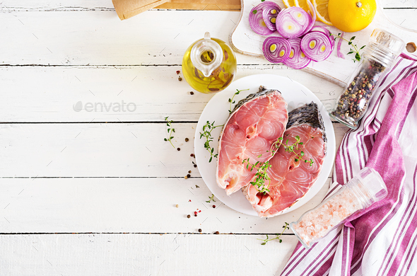 Raw steak of carp fish with lemon and thyme on white wooden background. - Stock Photo - Images
