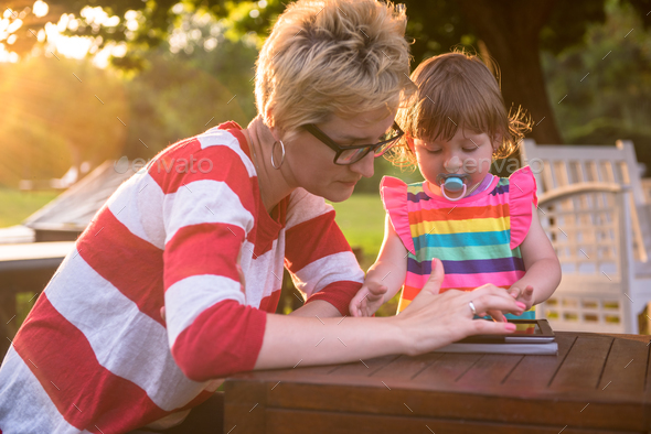 mom and her little daughter using tablet computer - Stock Photo - Images