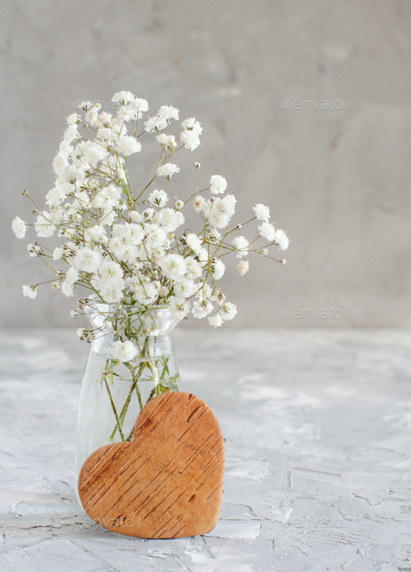 Bouquet of small white flowers and wooden hearts Stock Photo by