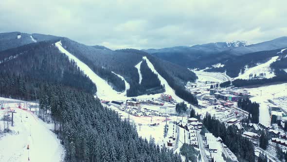 Aerial view of ski resort with people skiing down the hill and up lift.