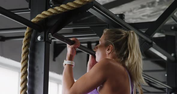 Side view athletic Caucasian woman doing chin ups alt