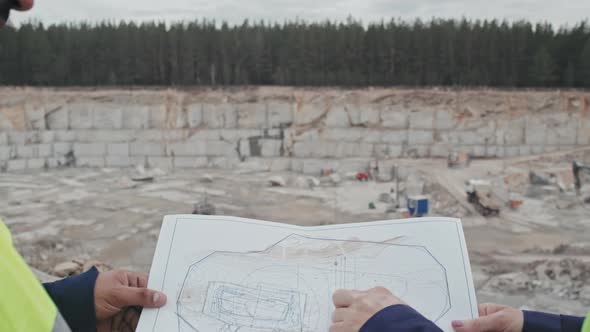 Workers Discussing Blueprint at Mining Site alt