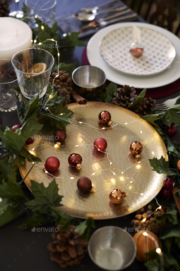 Christmas table setting with baubles on golden plate, bauble name card holder - Stock Photo - Images
