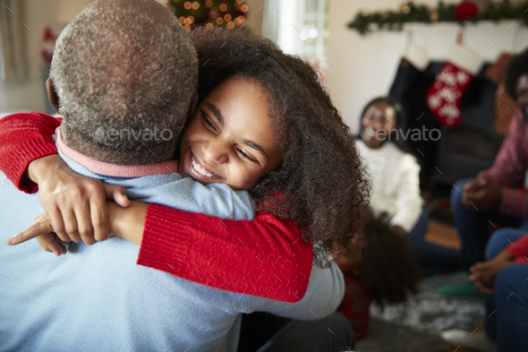 Granddaughter Giving Grandfather Hug As Multi Generation Family Celebrate Christmas At Home - Stock Photo - Images