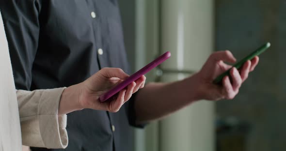 Two People at the Same Time Take Out Their Smartphones and Type Messages