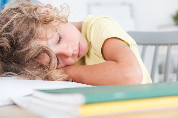 Close Up Of Sleeping Boy While Doing Homework On Desk Stock Photo