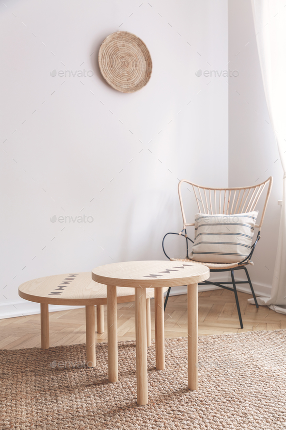 Two Small Coffee Tables And Wicker Chair With Pillow On It In Na Two Small Coffee Tables And Wicker Chair With Pillow On It In Na