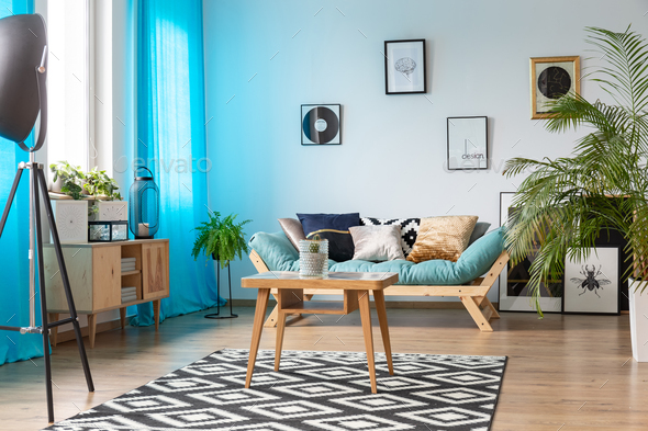 Wooden coffee table with cactus in glass vase placed on patterne - Stock Photo - Images