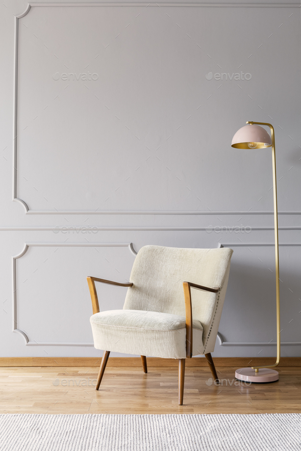 Real photo of pastel pink metal lamp standing by the white armch - Stock Photo - Images