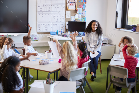 Young female infant school teacher sitting on a chair facing school ...