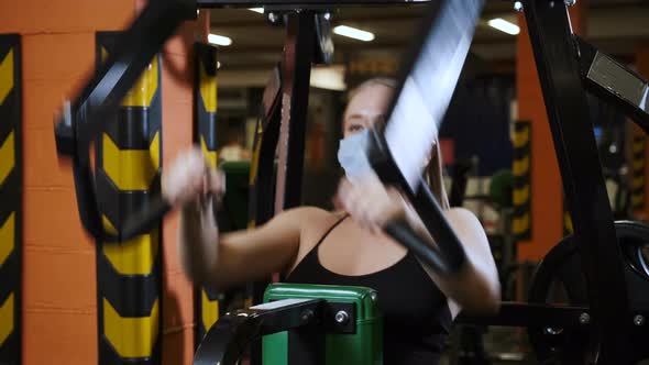 Workout in gym with covid-19 coronavirus precautions, using face mask. alt