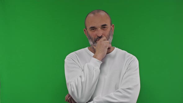 Confident Middle Aged Man in Holding Hand on Chin and Looking at Camera Thoughtfully While Posing alt