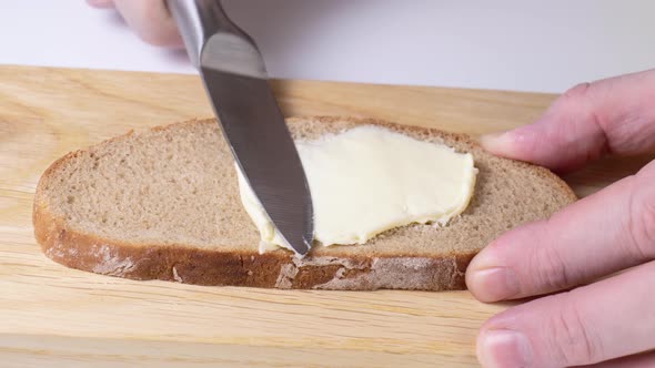 Spreading Butter on Bread with a Knife Closeup