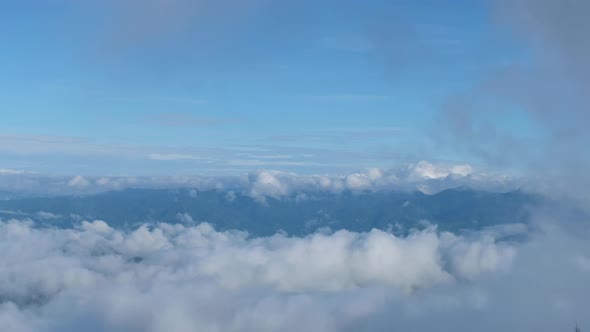 Aerial view of the sky and mountains on cloudy day by drone