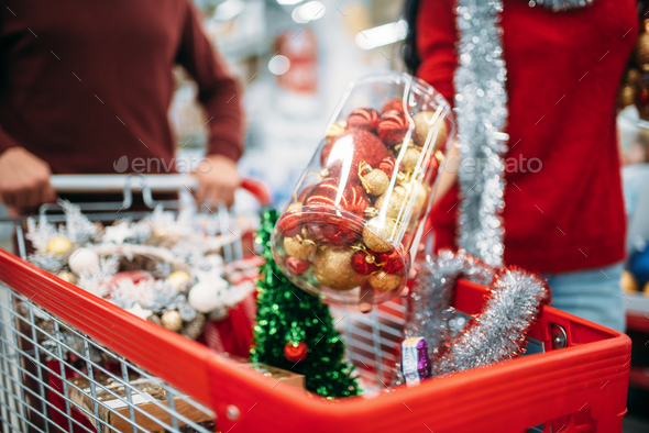 Young couple put in a cart Christmas decorations - Stock Photo - Images