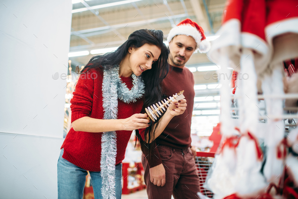Couple chooses christmas souvenir in supermarket - Stock Photo - Images