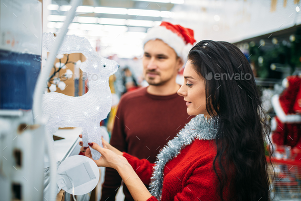 Couple looks on glass deer in supermarket - Stock Photo - Images