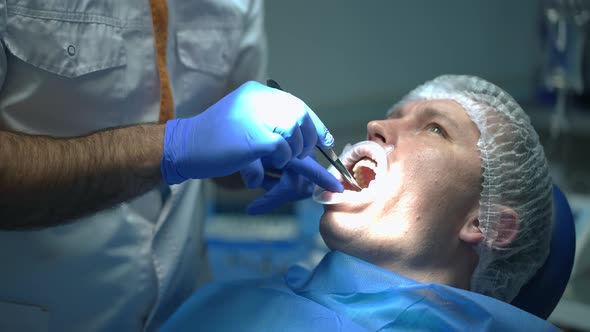 Unrecognizable Dentist Examining Oral Cavity of Patient in Dental Chair in Slow Motion alt