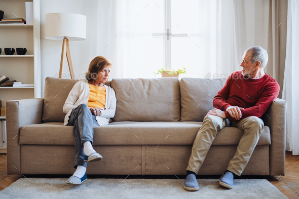 A Senior Sitting On Sofa At Home Having An Argument A Senior Sitting On Sofa At
