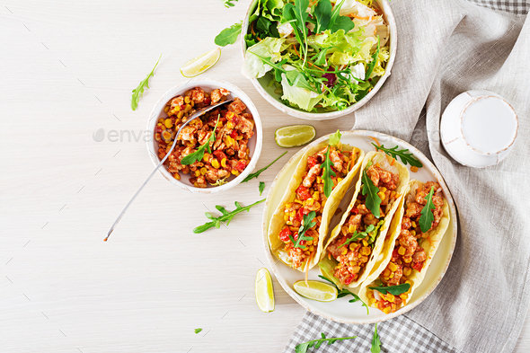 Mexican tacos with chicken meat, corn and tomato sauce.