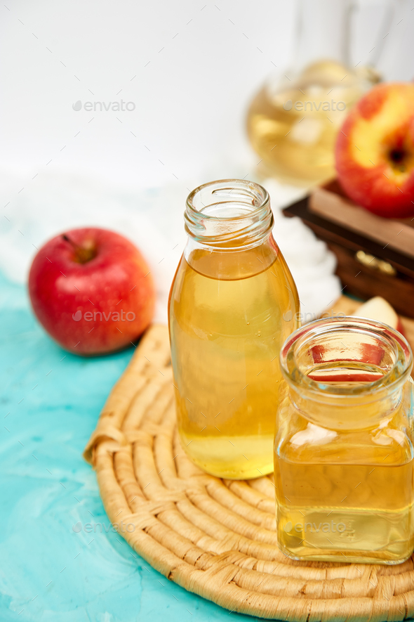 Glass Bottle of apple organic vinegar on blue background. - Stock Photo - Images